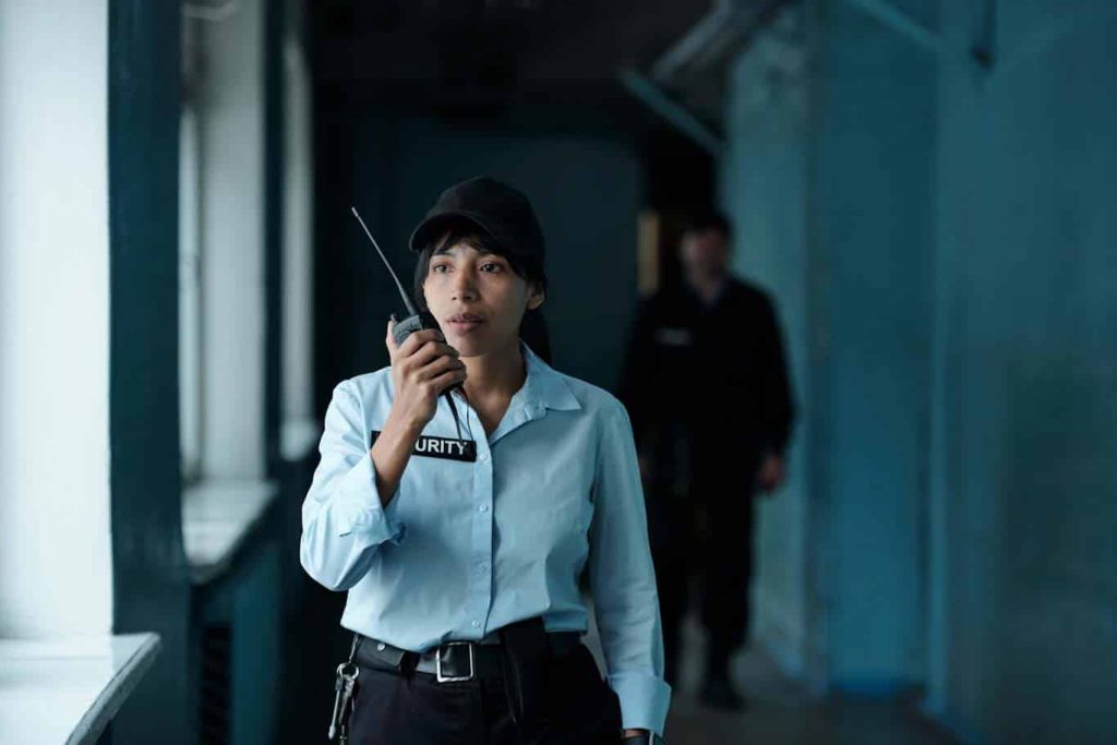 A female security guard responds on her walkie-talkie.