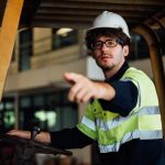 A forklift driver points to a dangerous situation report form pinned on the safety board. Learn more about mobile reporting dangerous situations at 1stReporting.com.