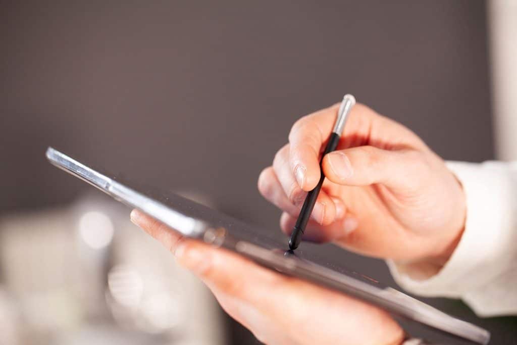 A safety manager writes tips for completing incident reports on a mobile tablet.