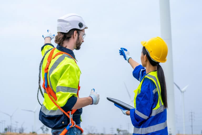 Two utilities workers discuss site hazards documented on a digital risk assessment form.