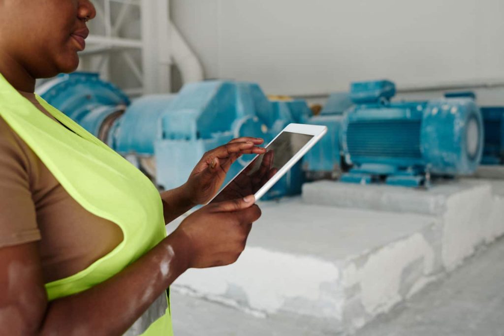A worker completes a facility inspection checklist on her mobile tablet. Learn more about mobile reporting and facility inspection templates at 1stReporting.com.
