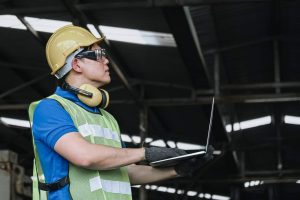 A worker uses a facility inspection checklist for safety audit documentation.