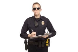 An officer reluctantly holds a use of force report form.