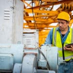 A construction worker uses a tablet to complete an equipment condition report