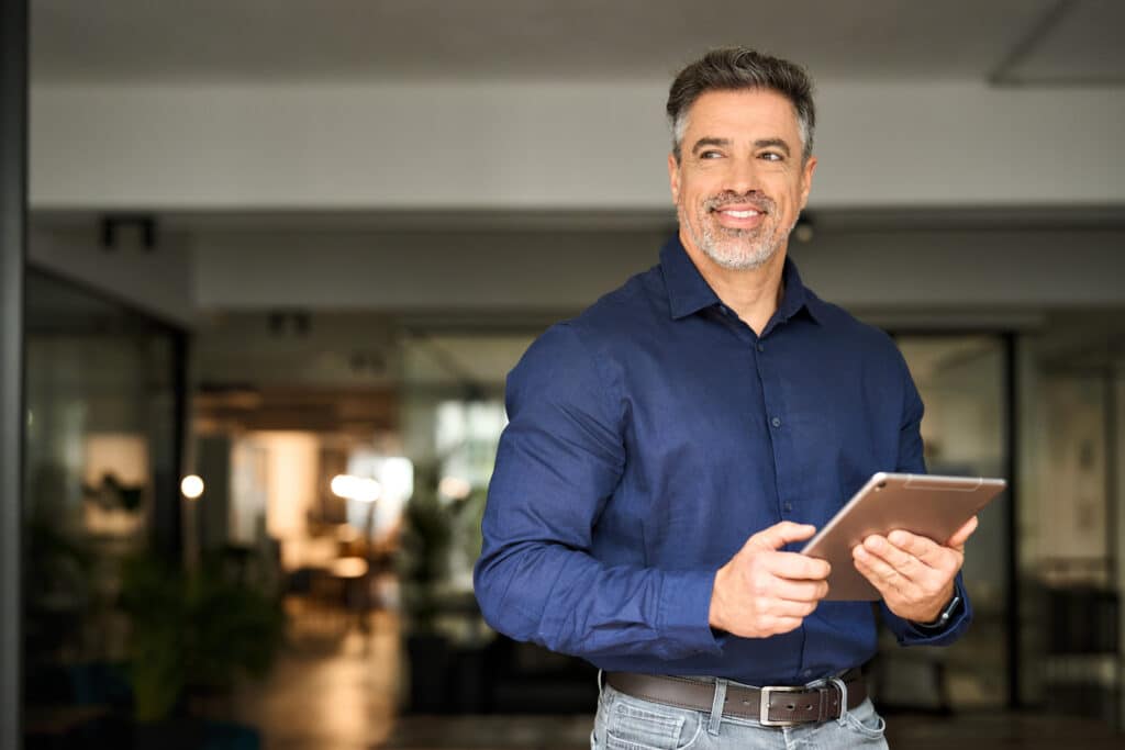 A manager happily uses a mobile form automation solution on a mobile tablet.