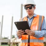A construction worker reviews a construction safety checklist on a mobile tablet.