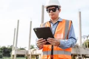A construction worker reviews a construction safety checklist on a mobile tablet.