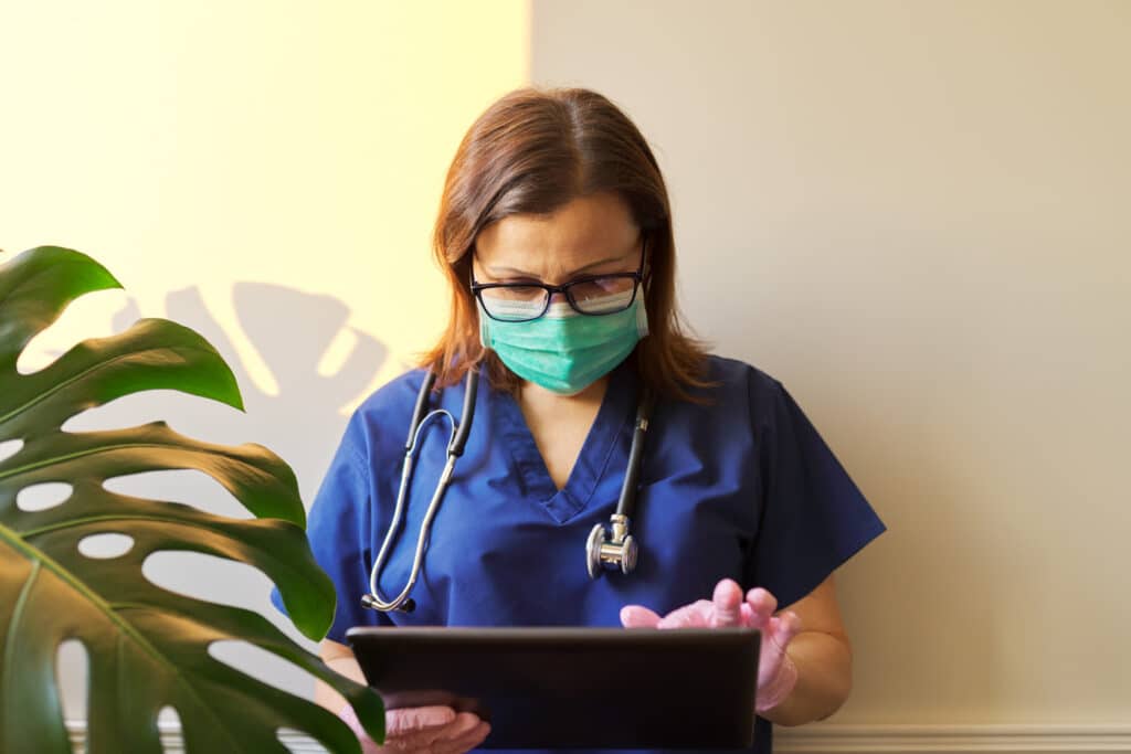 A doctor uses a tablet to complete a SOAP note template.