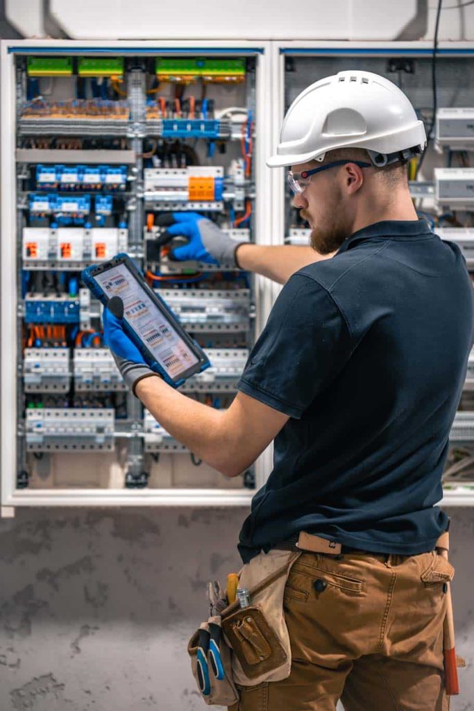 An electrician checks complex control circuits for factory equipment. Electrical professionals are using the 1st Reporting mobile app to make electrical inspections easier and more efficient. Learn more at 1stReporting.com.