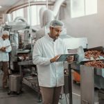 A food gmp audit checklist is used by an auditor in a food manufacturing facility.