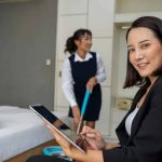 A hotel supervisor reviews a mobile housekeeping inspection report on a tablet.