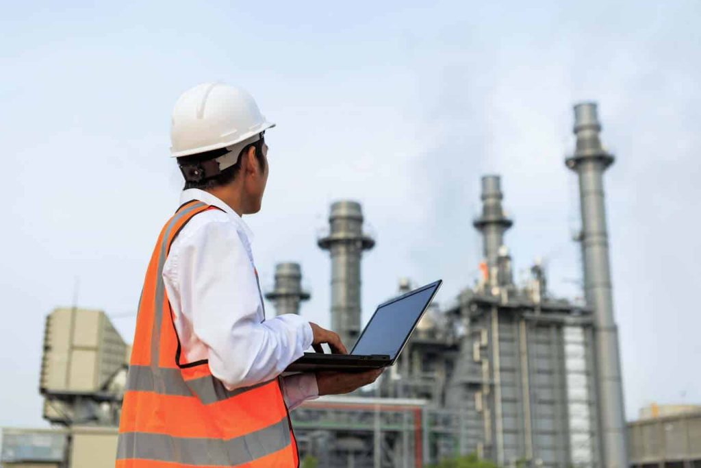 Digital field report templates, like those in the 1st Reporting application, are crucial for site operations. A worker at a power plant assesses conditions using 1st Reporting on his mobile laptop. Learn more about mobile reporting at 1stReporting.com.