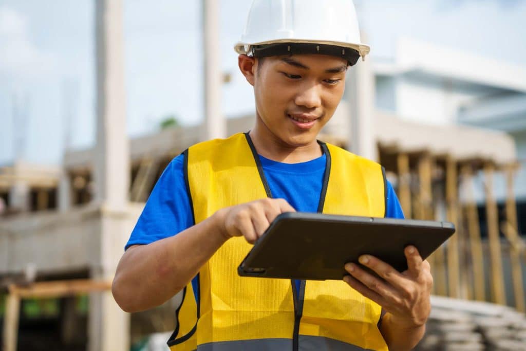 A contractor completes a Contractor Work Permit Form on a mobile tablet with 1st Reporting.