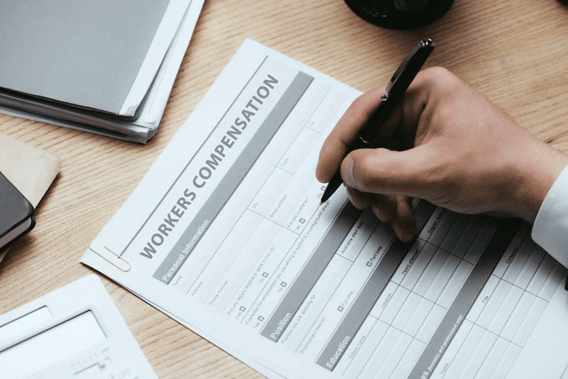 A person completing a worker's compensation form is shown in this file photo. Learn about Incident Management Challenges in Industries with Mobile Workforces at 1stReporting.com.
