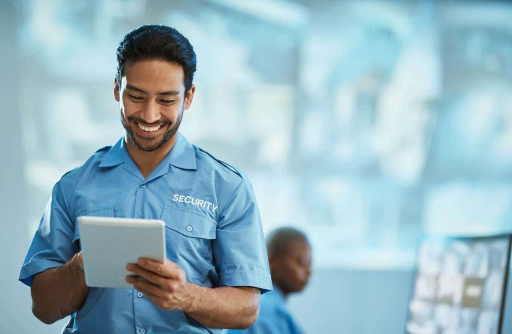 A security guard completes a building security checklist on a tablet. Learn more about mobile reporting at 1stReporting.com.