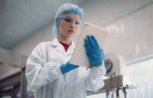 QC manager checks the Quality Control Checklist on a mobile device (tablet).