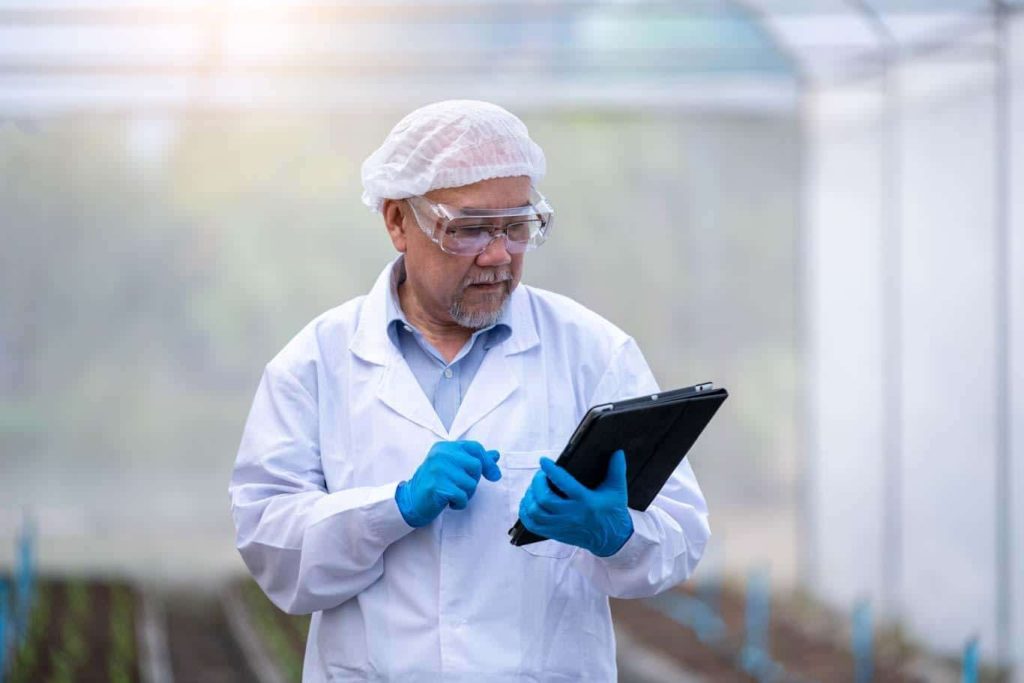 An agricultural worker uses a tablet to complete a compliance checklist. Learn more at 1stReporting.com.