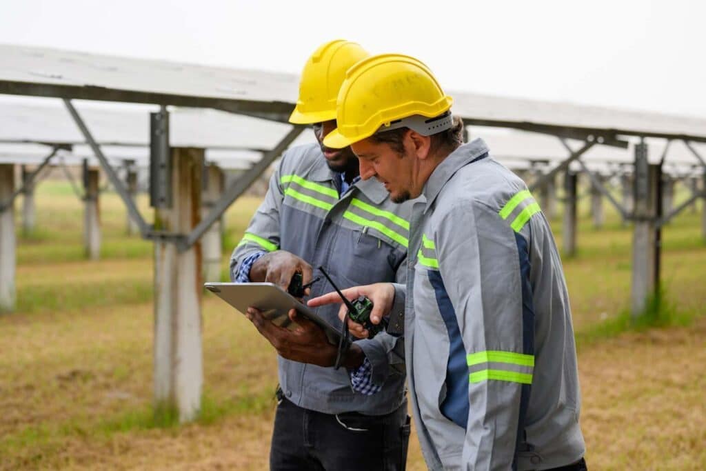 A team member helps guide his coworker through digital onboarding in utility field operations.