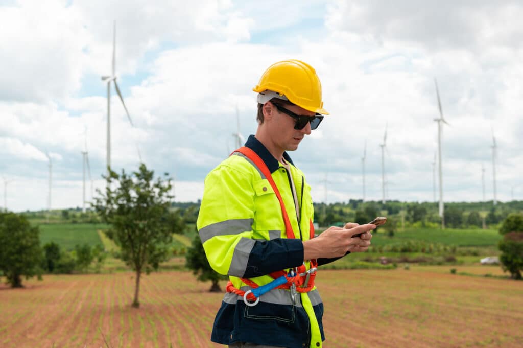 A utility worker completes a predictive maintenance report on his smartphone.