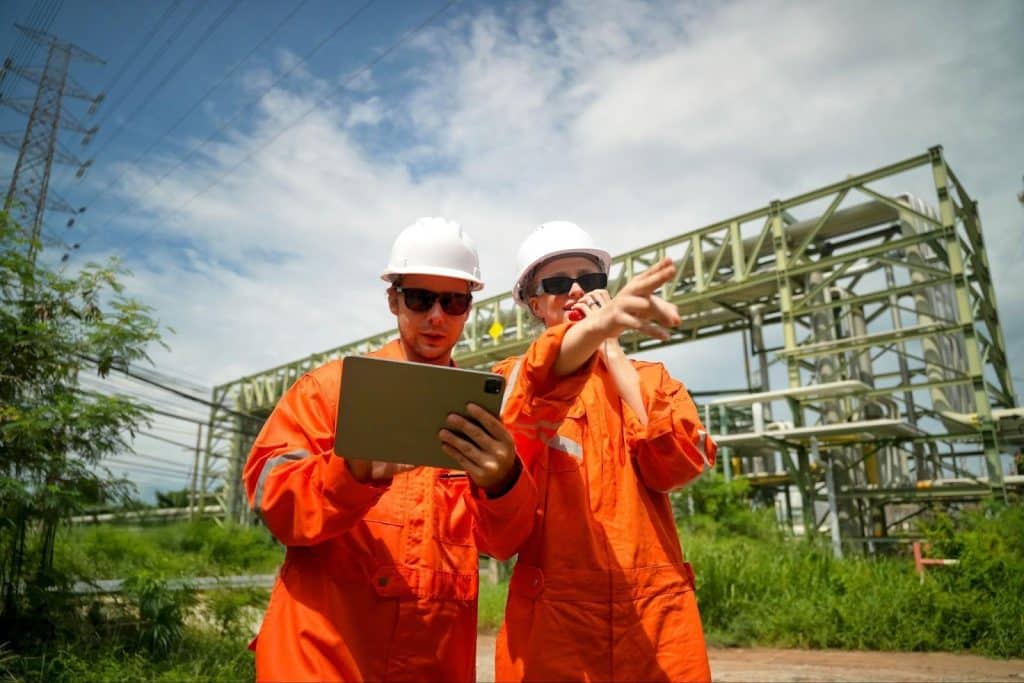 A team of inspectors uses a tablet to field-report at a power station for their utility organization.