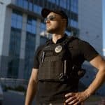 A security guard stands confidently knowing his security reporting software (security guard reporting app) keeps security clients happy.