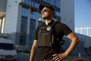 A security guard stands confidently knowing his security reporting software (security guard reporting app) keeps security clients happy.