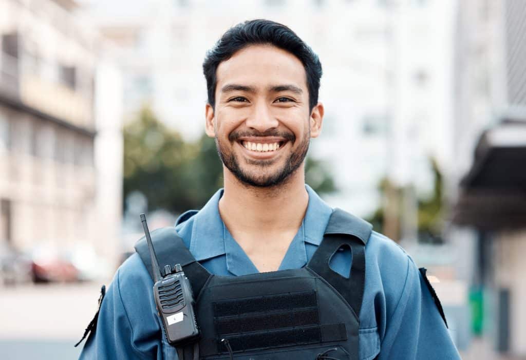A happy security officer who uses a security guard reporting app to easily document incidents.